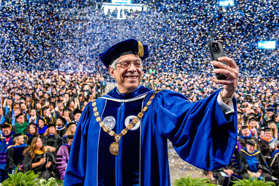 SLU President Pestello takes a selfie with the crowd at SLU's 2025 Commencement.