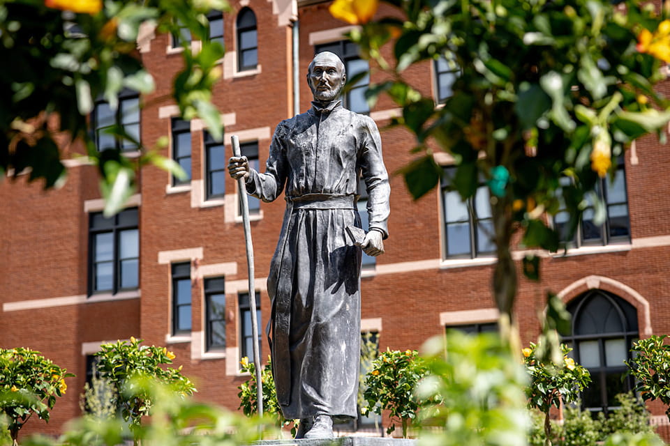A statue of Saint Ignatius standing in robes with a staff.