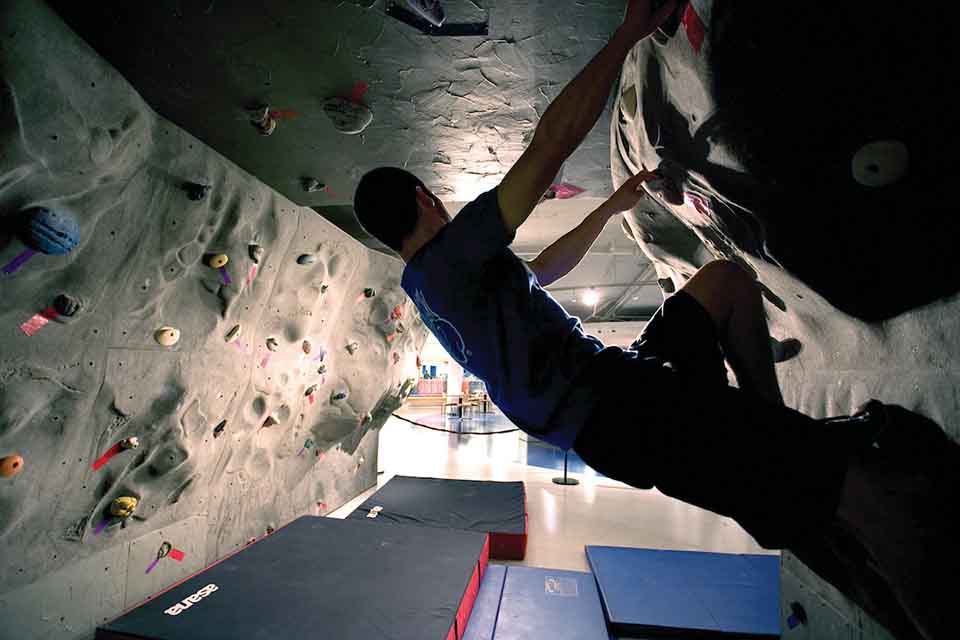 Student in profile using a climbing wall